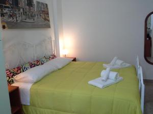 a bedroom with a green bed with towels on it at Alba B&B in Isernia