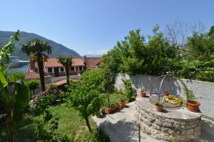 a garden with potted plants on a stone wall at Apartments Popovic 2 in Kotor