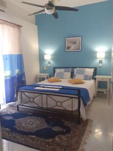 ガラヒディにあるElea Guesthouseの青い壁のベッドルーム1室