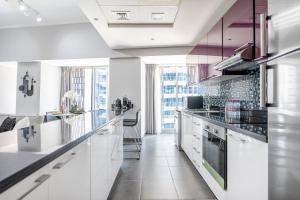 a kitchen with white counters and a large window at Luxury Iconic Cayan Tower - Free 5 star Beach Resorts Access! in Dubai