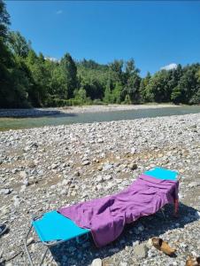 una manta y sillas en una playa rocosa junto a un río en La Quercia sul Lao Bed&Breakfast, en Cannecelle