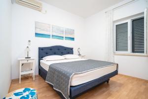 a bedroom with a bed and two windows at Apartments Villa Ivka in Dubrovnik