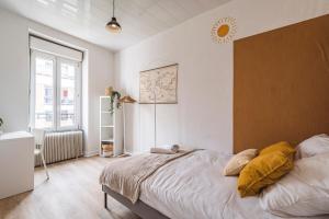 ein Schlafzimmer mit einem Bett mit gelben Kissen darauf in der Unterkunft Le Zola - charmant 2 chambres - centre gare in Reims