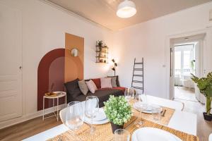 ein Wohnzimmer mit Sofa und Tisch in der Unterkunft Le Zola - charmant 2 chambres - centre gare in Reims