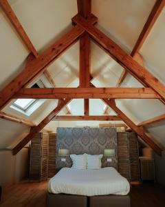 a bedroom with a white bed in the attic at Hotel Ter Zuidhoek in Roeselare