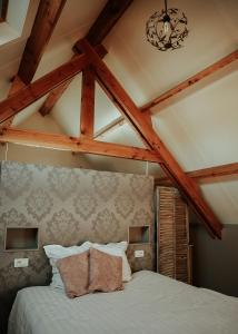 a bedroom with a white bed with wooden beams at Hotel Ter Zuidhoek in Roeselare