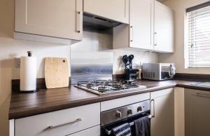 a kitchen with white cabinets and a stove top oven at Beautiful Home in Kingston-Upon-Hull in Hull