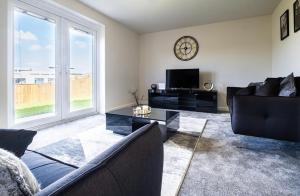 un soggiorno con divano e orologio sul muro di Beautiful Home in Kingston-Upon-Hull a Hull