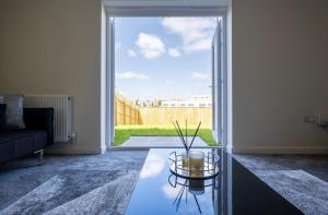 a living room with a couch and a glass table at Beautiful Home in Kingston-Upon-Hull in Hull