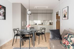 cocina y sala de estar con mesa y sillas en RentPlanet - Nowa Manufaktura, en Wroclaw