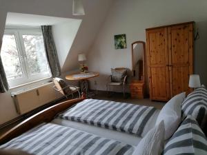 een slaapkamer met 2 bedden, een bureau en een raam bij Am Elbradweg - Nichtraucher-Gästezimmer Weiland in Dresden