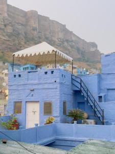 a blue building with a staircase in front of a mountain at Bristows Haveli Homestay in Jodhpur