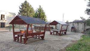 two wooden benches with a gazebo at Hotel Slobi in Štúrovo