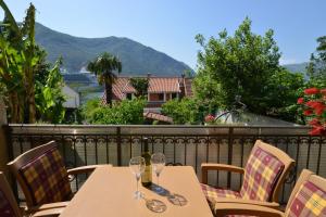 a table with two wine glasses on a balcony at Apartments Popovic 2 in Kotor
