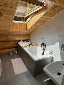 a bathroom with a bath tub and a sink at Wikno Villa in Nidzica