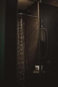 a shower in a dark room with water in it at BLACK HOUSE - premium holiday guest house in Priedkalne