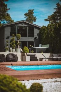 a house with a swimming pool in a yard at BLACK HOUSE - premium holiday guest house in Priedkalne