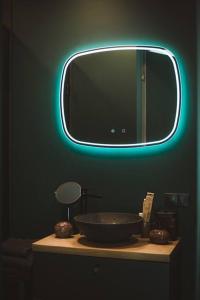 a bathroom with a mirror and a bowl on a counter at BLACK HOUSE - premium holiday guest house in Priedkalne