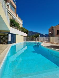 a swimming pool in a building with blue water at Dernier étage d'une maison in Roquebrune-Cap-Martin