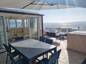 a patio with a table and chairs on a balcony at Dernier étage d'une maison in Roquebrune-Cap-Martin +4 photos