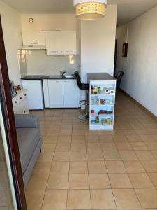 una pequeña cocina con nevera pequeña en una habitación en Joli studio cabine confort 28m2 a 200m de la plage, en Canet-en-Roussillon