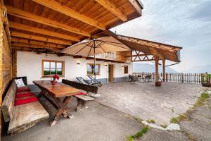 eine Außenterrasse mit einem Tisch und einem Sonnenschirm in der Unterkunft Ferienhaus Mutlechnerhof in Kuens