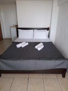 a bedroom with a bed with two towels on it at ΕΝΟΙΚΙΑΖΟΜΕΝΟ ΔΩΜΑΤΙΟ ΜΕ ΘΕΑ ΣΤΗΝ ΕΞΟΧΗ in Rodhókipos