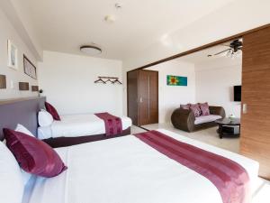 ein Hotelzimmer mit 2 Betten und einem Sofa in der Unterkunft Cozy Stay In Itoman in Itoman