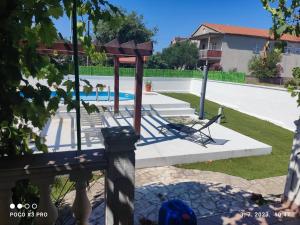 a playground in a yard with a swimming pool at Bruna's apartment in Vrulje