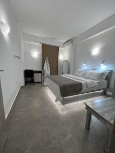 a bedroom with a large bed and a table at Petit Homme by Andreas in Perissa
