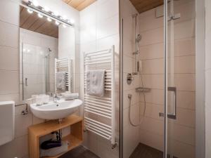 ein weißes Bad mit einem Waschbecken und einer Dusche in der Unterkunft Gästehaus Gollner in Fieberbrunn