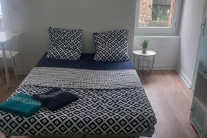 a bed with blue and white sheets in a room at LE MONISTROL in Monistrol-sur-Loire