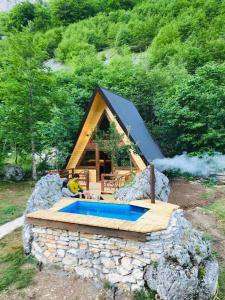 a small house with a swimming pool on a rock at Etno apartmani Komarnica in Šavnik