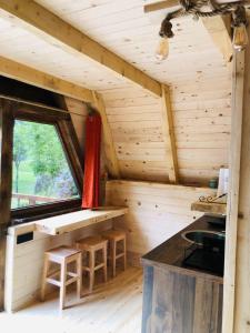a wooden cabin with a table and stools in it at Etno apartmani Komarnica in Šavnik