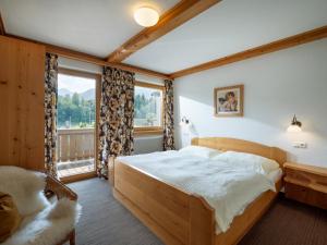 ein Schlafzimmer mit einem Bett und einem großen Fenster in der Unterkunft Gästehaus Gollner in Fieberbrunn
