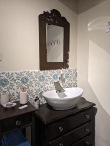 La salle de bains est pourvue d'un lavabo et d'un miroir. dans l'établissement Chez Nick et Martine suite privative, à Palinges