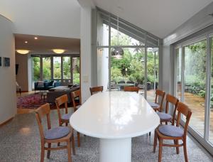 a dining room with a white table and chairs at 25 Min to the Center - 220 m2 Artist's House South of Munich - for Vacation or Great Workshops in Oberhaching