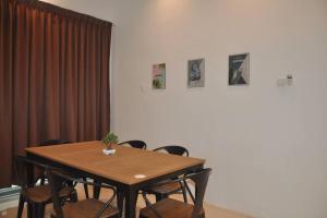 uma mesa de jantar com cadeiras e quadros na parede em ComfortZone~2, Spacious Semi-Detached House em Kuah