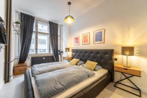 sypialnia z łóżkiem z czarnym zagłówkiem w obiekcie Sunny Central Apartment on Wenceslas Square by easyBNB w Pradze