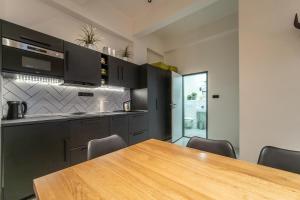 kuchnia z drewnianym stołem i krzesłami w obiekcie Sunny Central Apartment on Wenceslas Square by easyBNB w Pradze