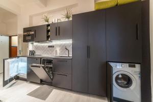 a kitchen with gray cabinets and a washer and dryer at Sunny Central Apartment on Wenceslas Square by easyBNB in Prague