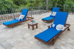 3 sillas azules y una mesa en el patio en Villa Ilir en Neum