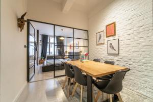 jadalnia z drewnianym stołem i krzesłami w obiekcie Sunny Central Apartment on Wenceslas Square by easyBNB w Pradze