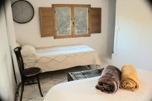 - une chambre avec deux lits, une chaise et une fenêtre dans l'établissement Mirador de Mijares, à Los Pertegaces