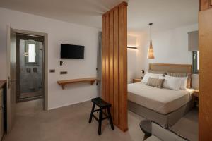 um quarto de hotel com uma cama e uma televisão em Makava Suites Naxos em Naxos Chora