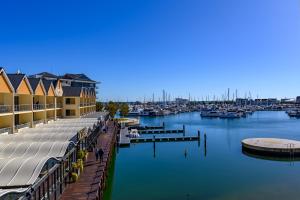 un puerto deportivo con muelle y barcos en el agua en Dolphin Quay Apartments en Mandurah