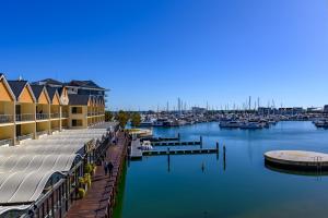 a marina with a dock and boats in the water at Dolphin Quay Apartments in Mandurah