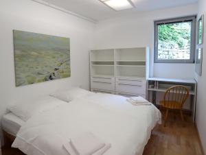 1 dormitorio con 2 camas, escritorio y ventana en 25 Min to the Center - 220 m2 Artist's House South of Munich - for Vacation or Great Workshops, en Oberhaching