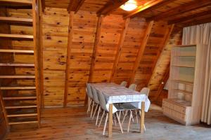 - une table et des chaises dans une chambre dotée de murs en bois dans l'établissement Nowa Holandia, à Sieraków