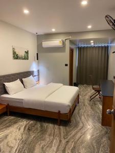 1 dormitorio con 1 cama y escritorio en una habitación en Luxe Inn, en Kannur